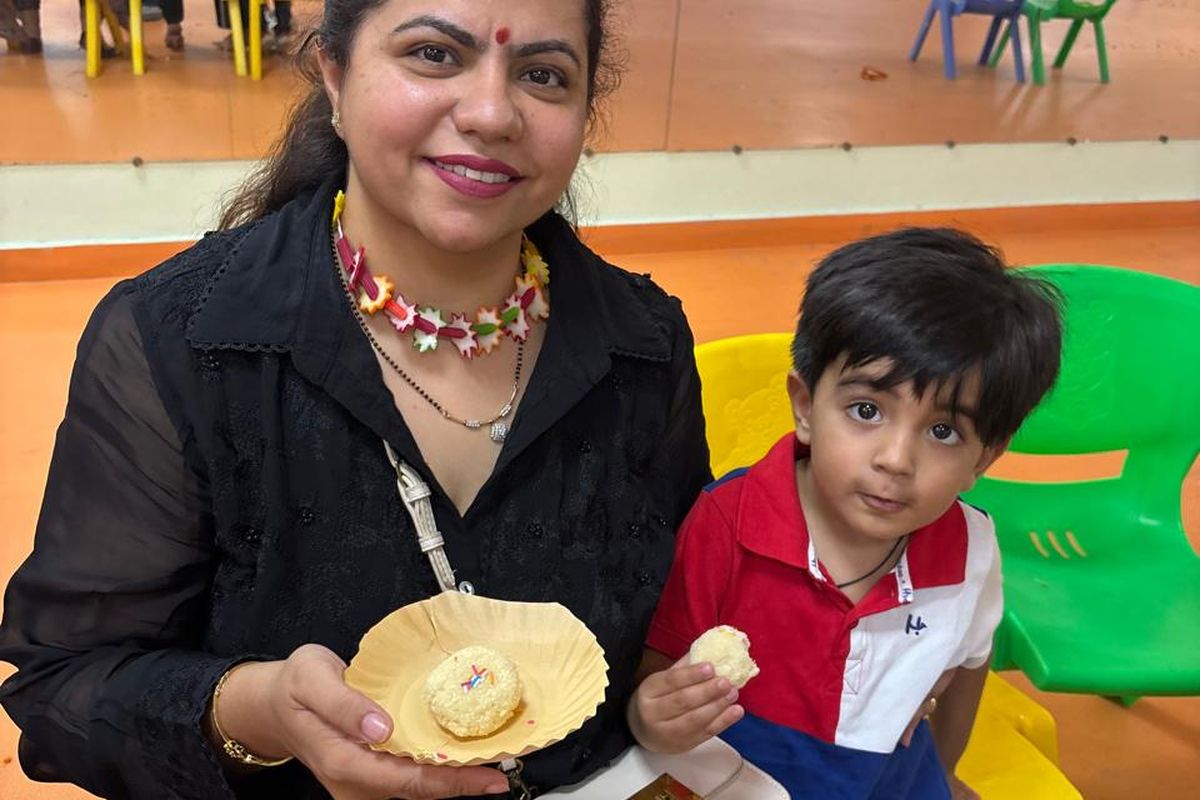 A teacher showing a craft activity to a young child in the classroom