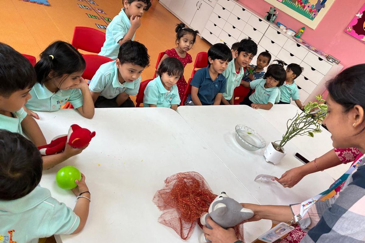 Children gathered around a table with their teachers during a hands-on science activity
