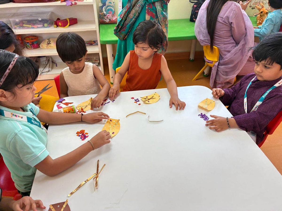 Children and teachers working on a colourful art and craft activity at a classroom table in DLF Phase 3