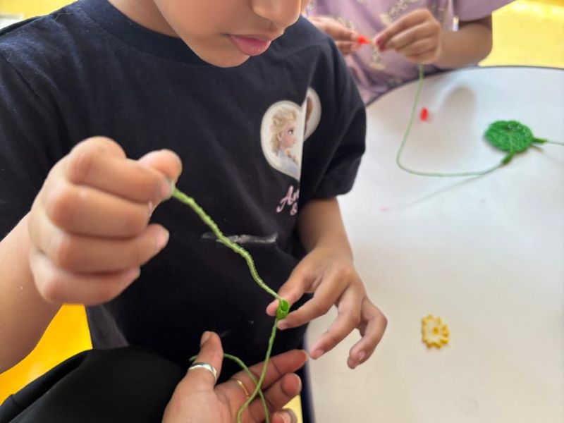 Close-up of a child threading beads onto a string