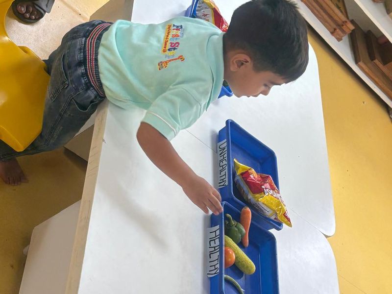 Sorting and matching materials laid out on a low table beside the classroom shelves